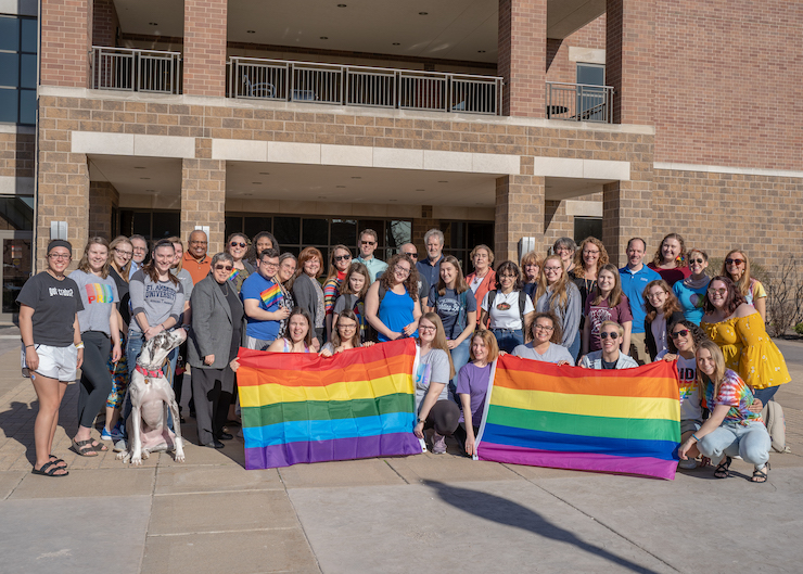 SAU students and staff pose with two rainbow flags, commonly known as the LGBT+ pride flag