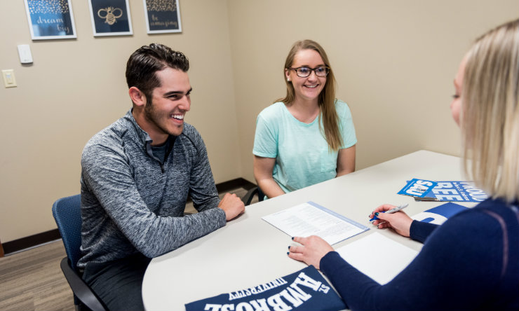 Two students meet with admissions counselor