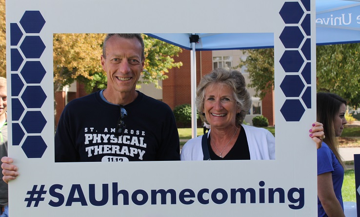 two people holding homecoming sign